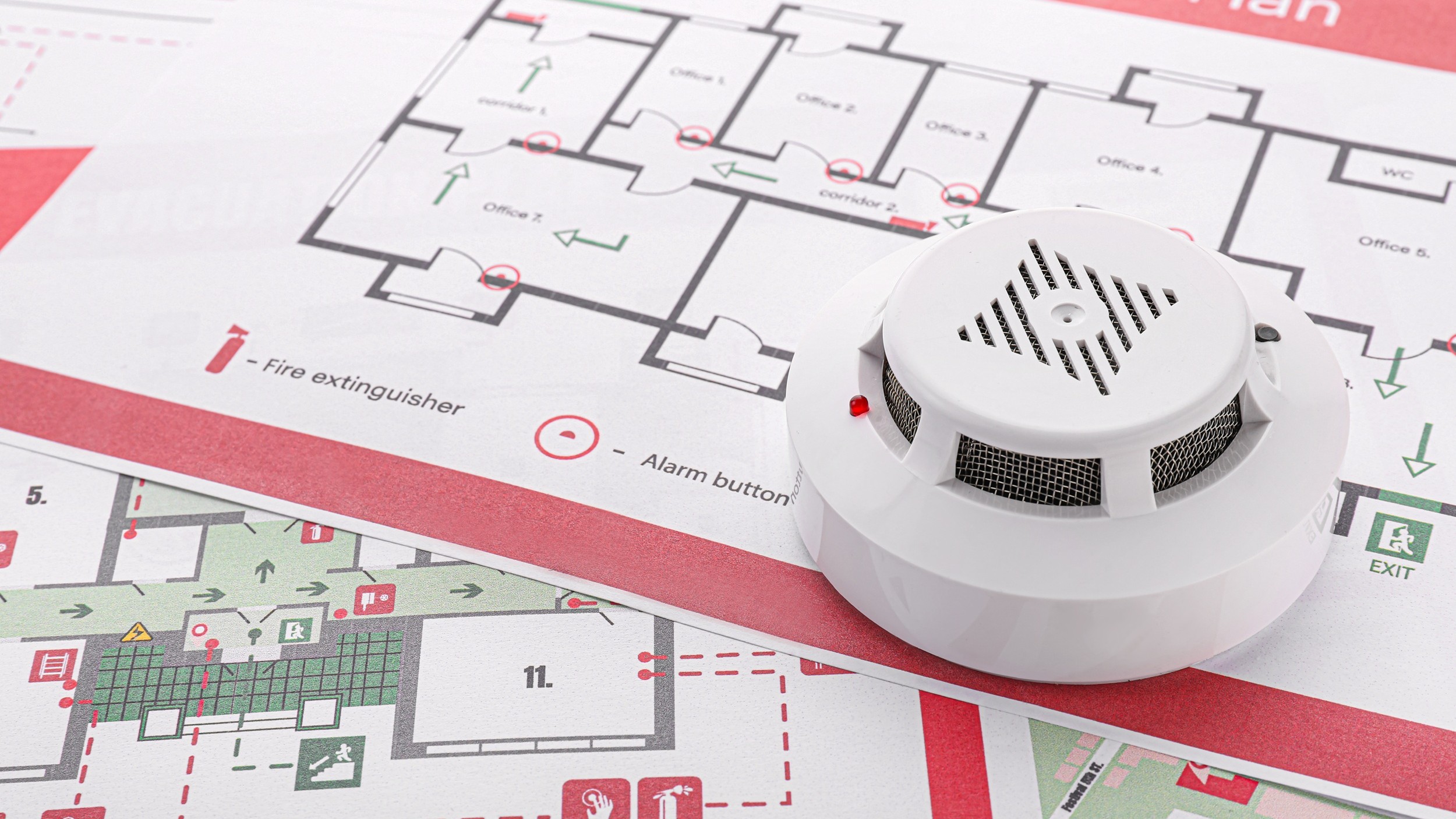 A smoke detector on top of evacuation plans