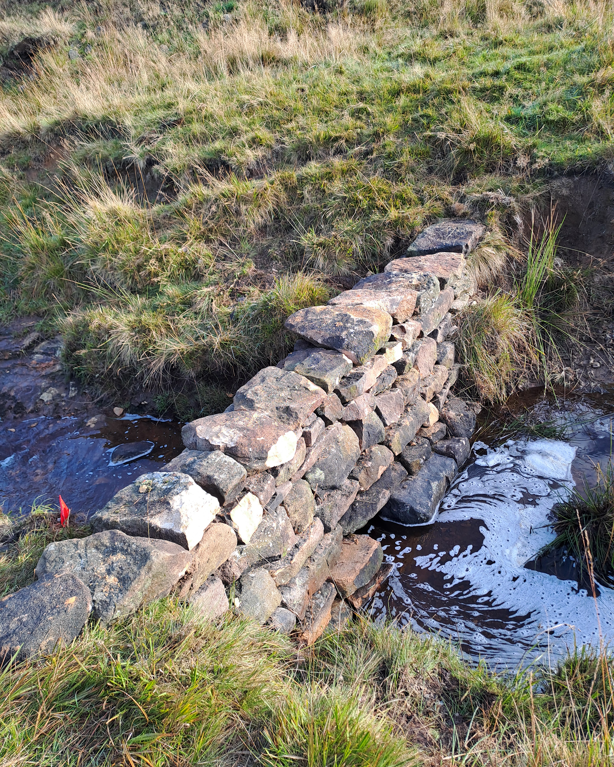Stone dam in Yorkshire with hold in the middle to slow down water and remediate flooding
