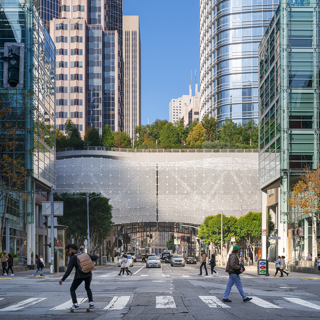 People crossing a road with the transit center in the background