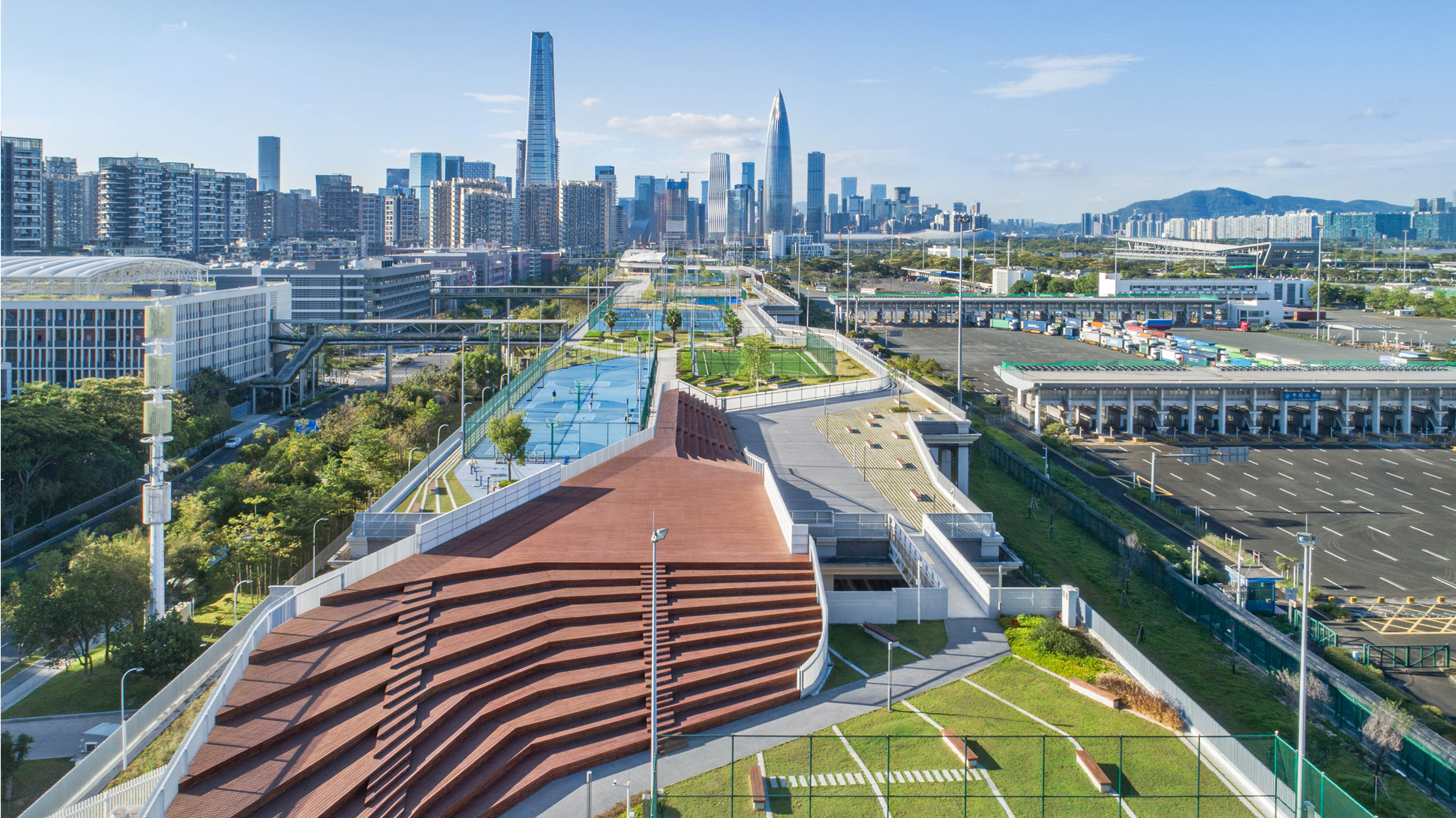 Aerial view of blue tennis courts with city skyline in background