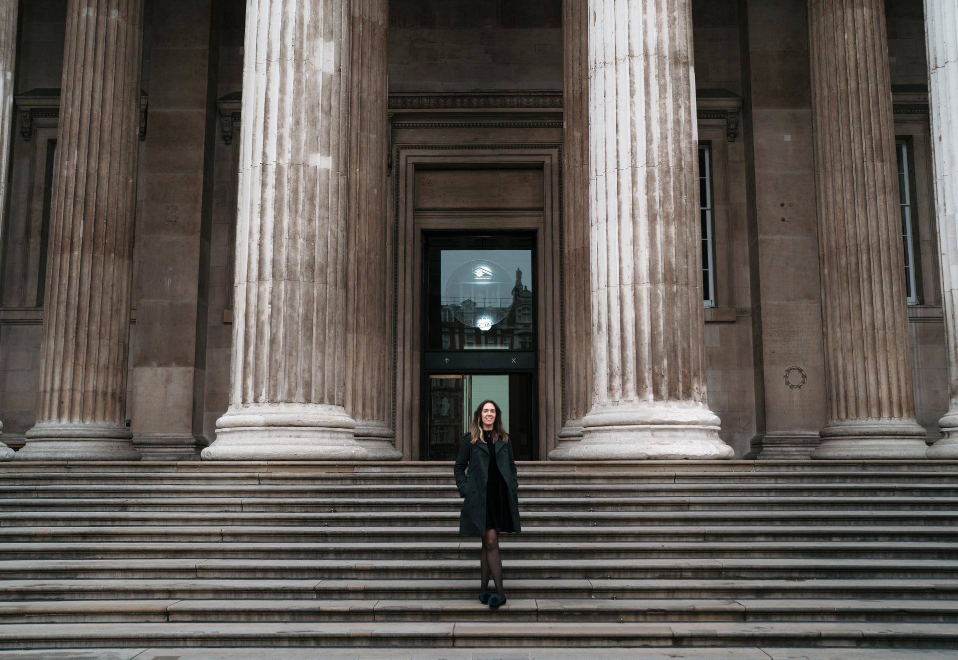 Katharine Cary stood on the steps leading up to a glass door framed by huge columns