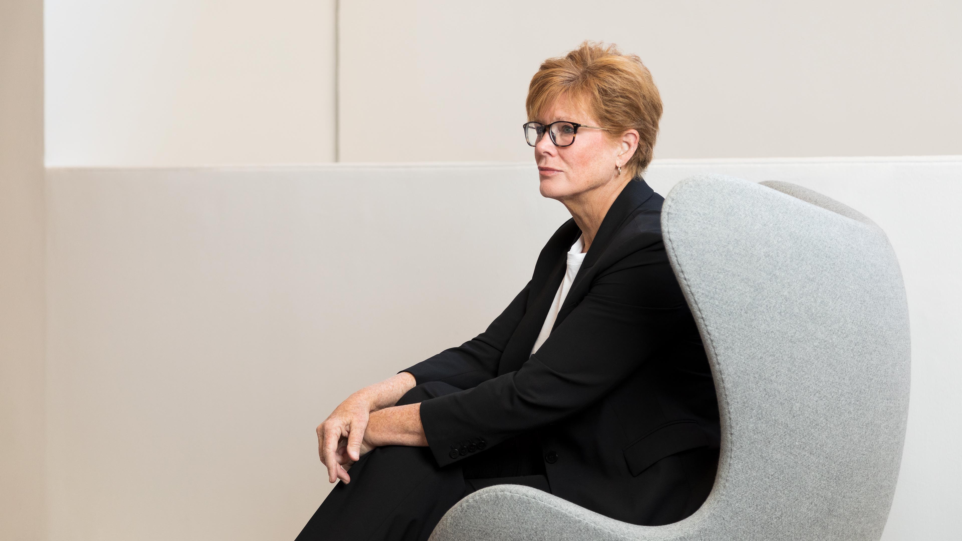 Ann Gray sat in grey chair looking off camera