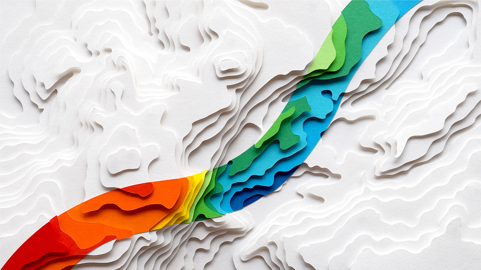 Paper cut white layers with rainbow coloured strip running through