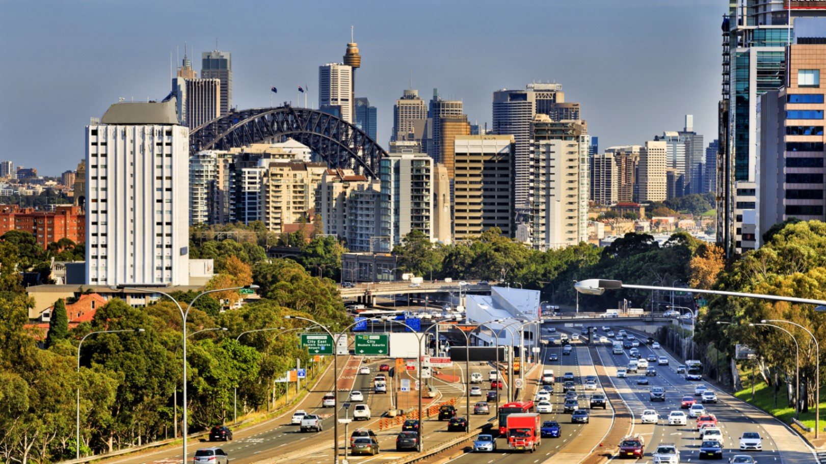 Cars on a motorway during rush hour in Sydney, Australia with skyscrapers in the background