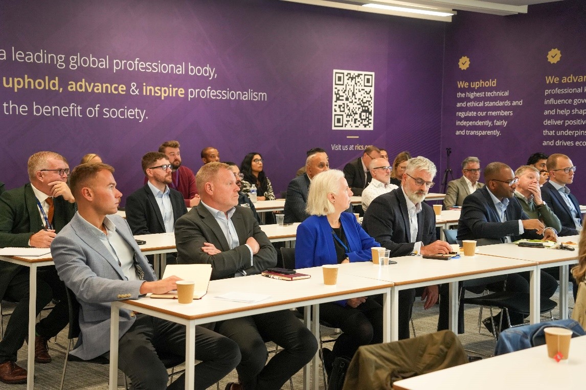 Picture of the attendees at the event sat down listening