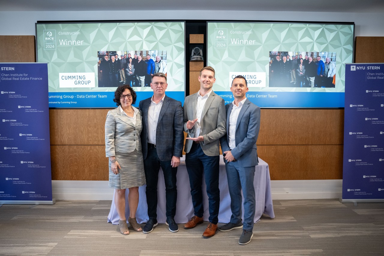 Construction Award Winner - Cumming Group: A group photoshoot of the winning team receiving the Construction Award from Tina Paillet FRICS, RICS President