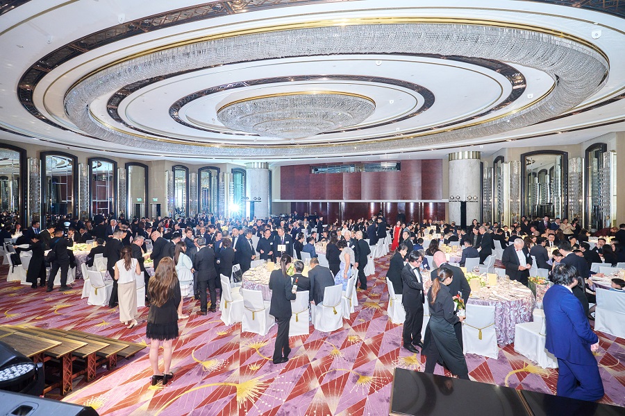 Image of a grand ballroom with hundreds of people in formal attire.