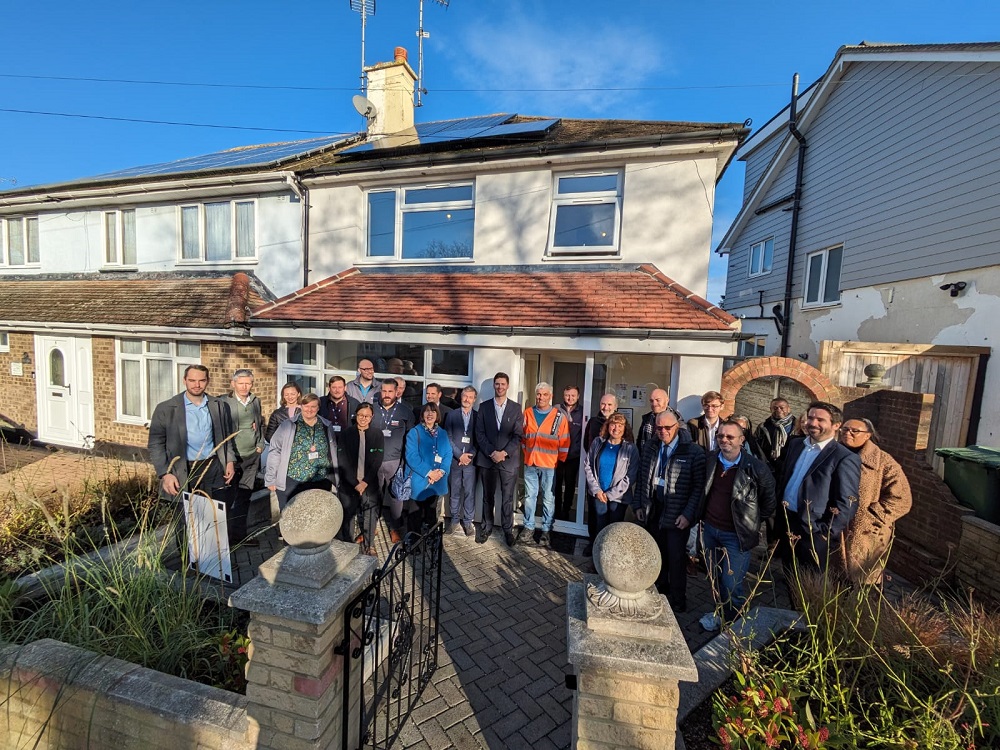 A group of people standing in front of a semi-detached eco fit home.